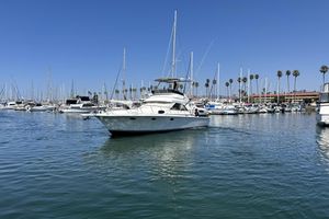 Trojan 40 Sport Fisherman 3208 Cat Diesel 1990 Trojan 40 Sport Fisherman yacht in a marina, surrounded by sailboats and palm trees.