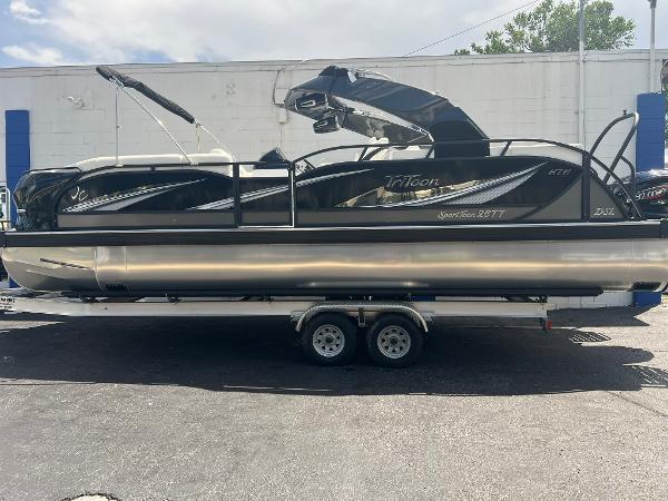 JC 26 SportToon TT DSL 2025 JC 26 SportToon TT DSL pontoon boat on trailer, sleek black design.