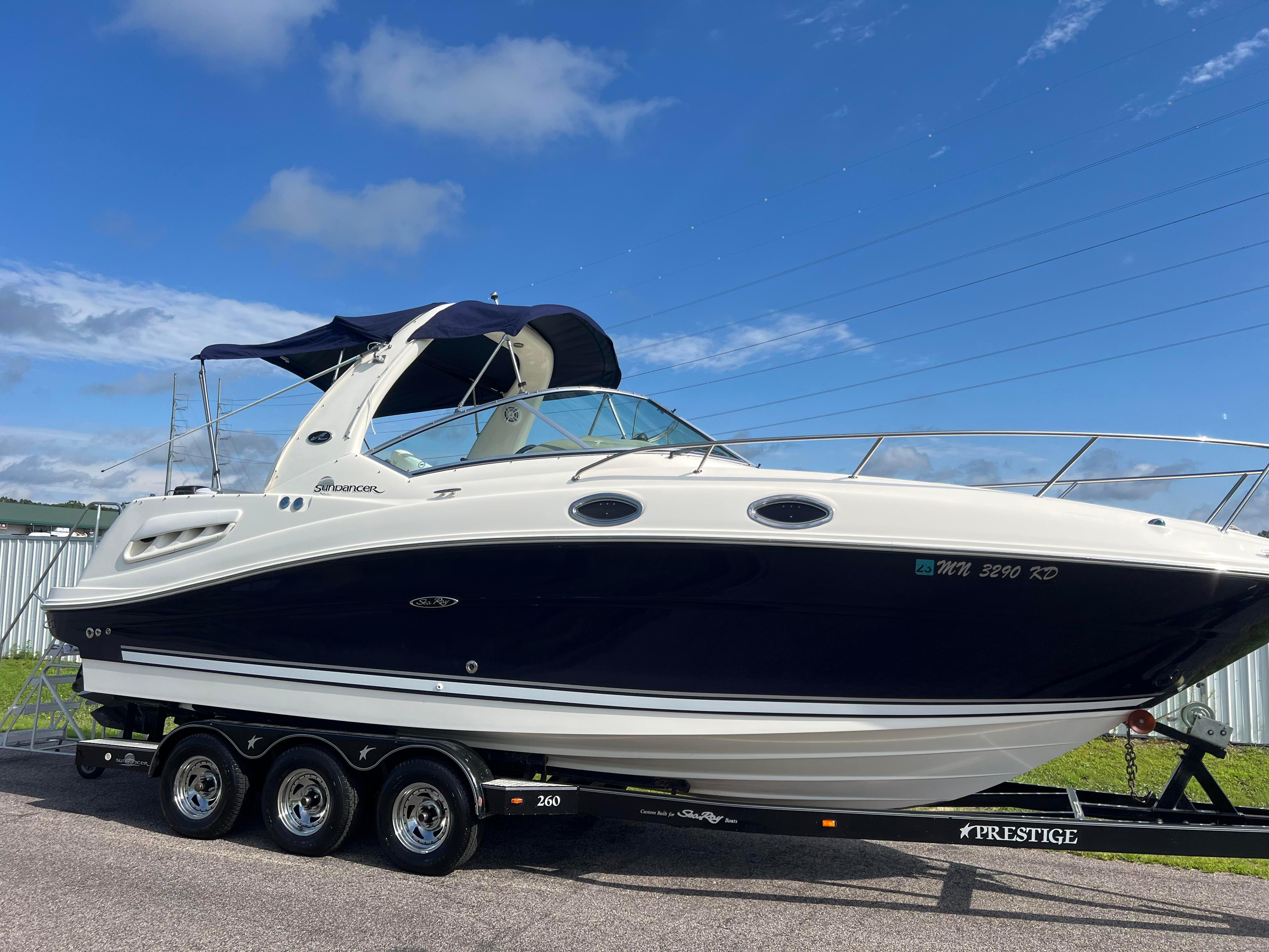 Sea Ray 260 Sundancer 2006 Sea Ray 260 Sundancer boat on trailer under clear blue sky.