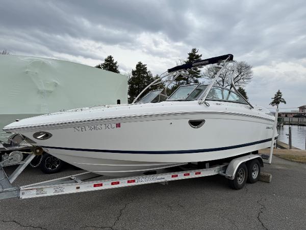 Cobalt 242 2013 Cobalt 242 boat on trailer, parked outdoors under cloudy sky.