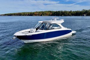 Regal LS36 2025 Regal LS36 boat cruising on a serene lake with forested shoreline.