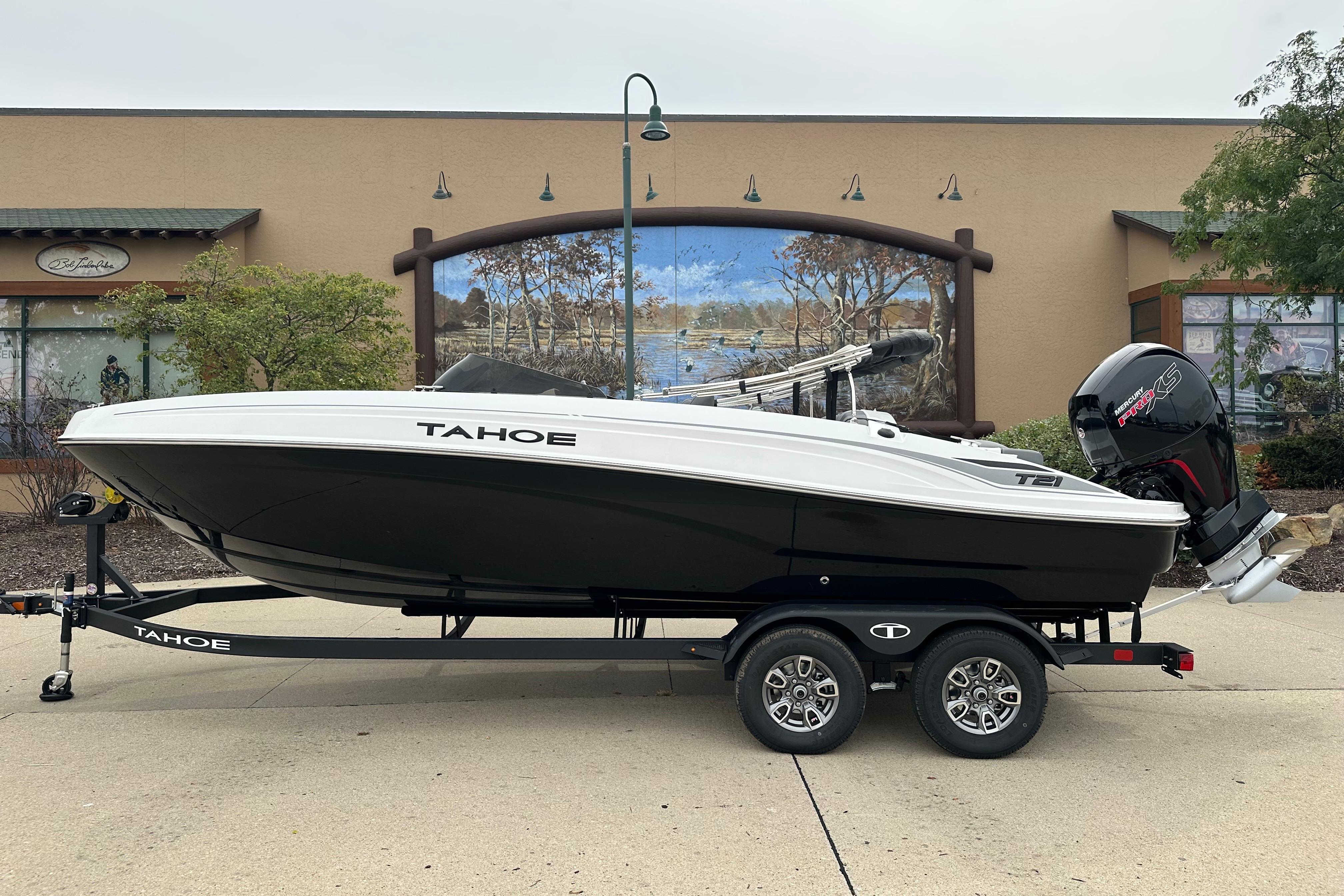 Tahoe T21 2026 Tahoe T21 boat on trailer, parked outdoors, showcasing sleek design and powerful engine.