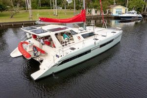 St. Francis 50 MK 2 2017 St Francis 50 MK 2 catamaran with red sail, docked in a calm canal.