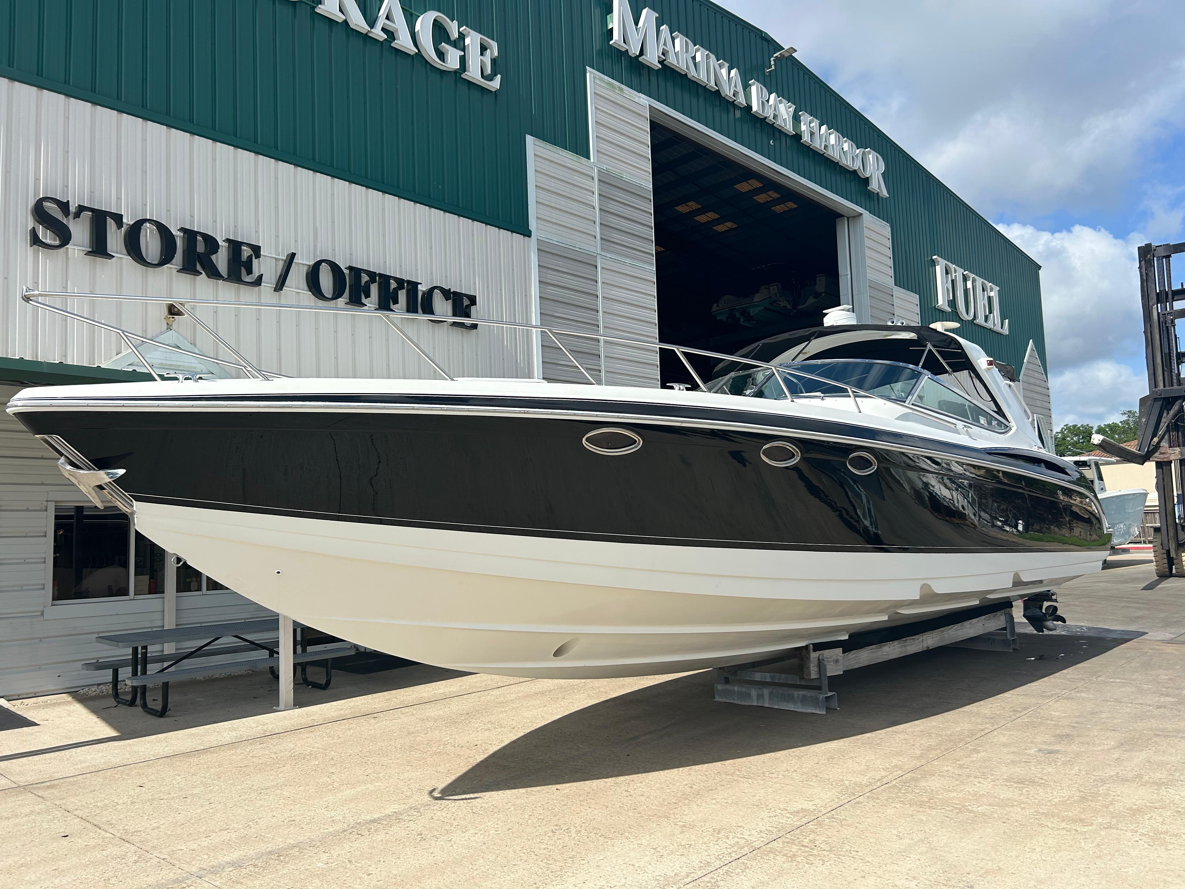 Formula 400 Ss 2004 Formula 400 SS boat at marina storage, black and white exterior, sunny day.