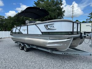 Crest Caribbean LX 230 2024 Crest Caribbean LX 230 pontoon boat on trailer, parked outdoors.
