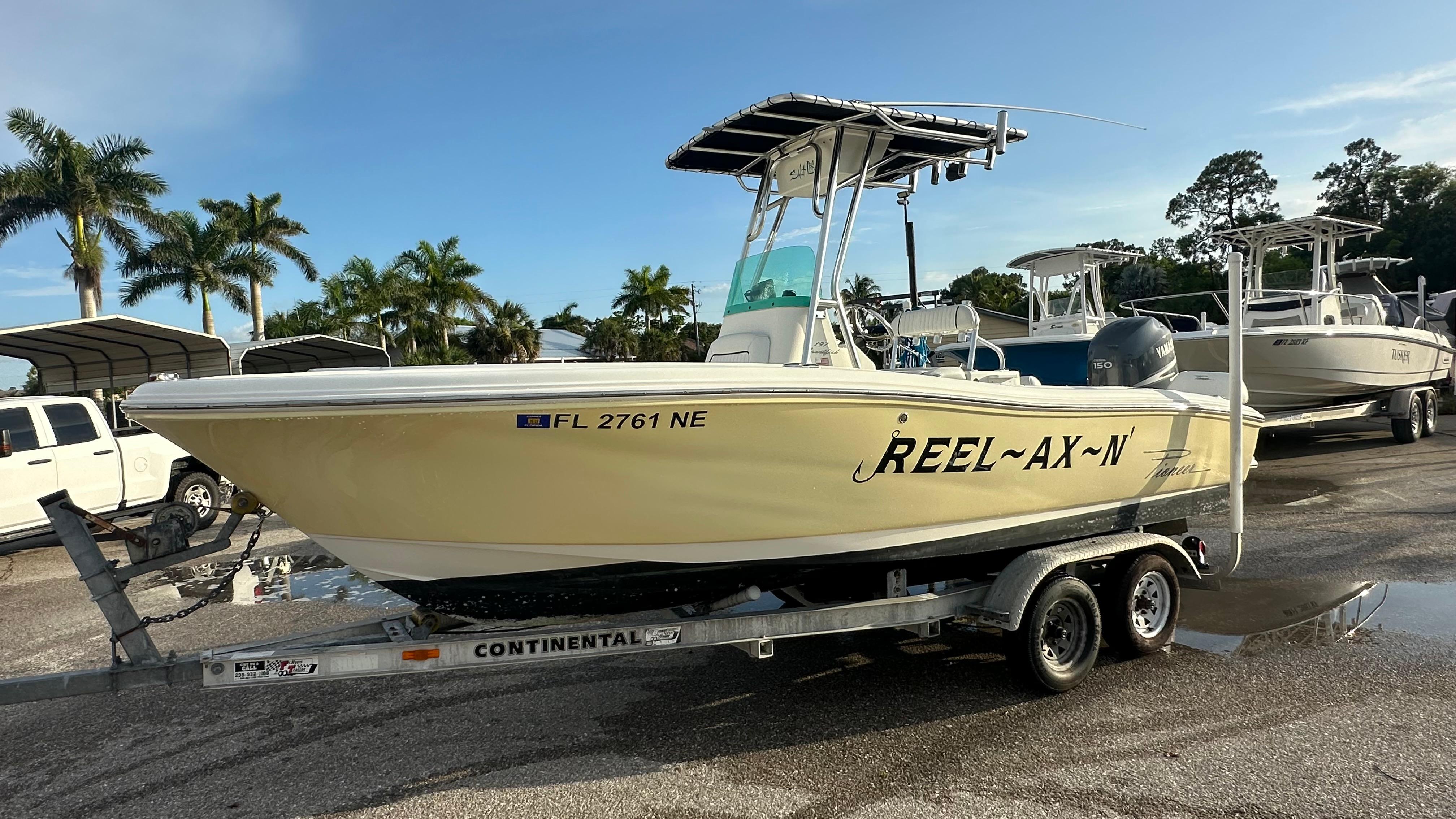 Pioneer 197 Sportfish 2006 Pioneer 197 Sportfish boat on trailer, parked outdoors with palm trees in background.
