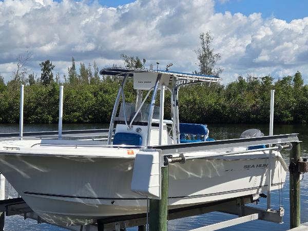 Sea Hunt Triton 220 2008 Sea Hunt Triton 220 boat docked on a lift by a scenic waterway.