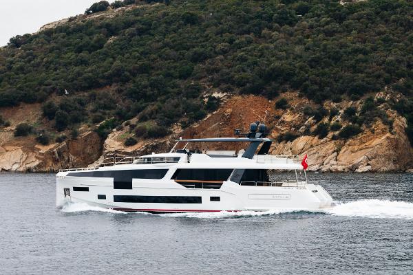Sirena 88 Luxury Sirena 88 yacht cruising near a rocky coastline, 2021 model.