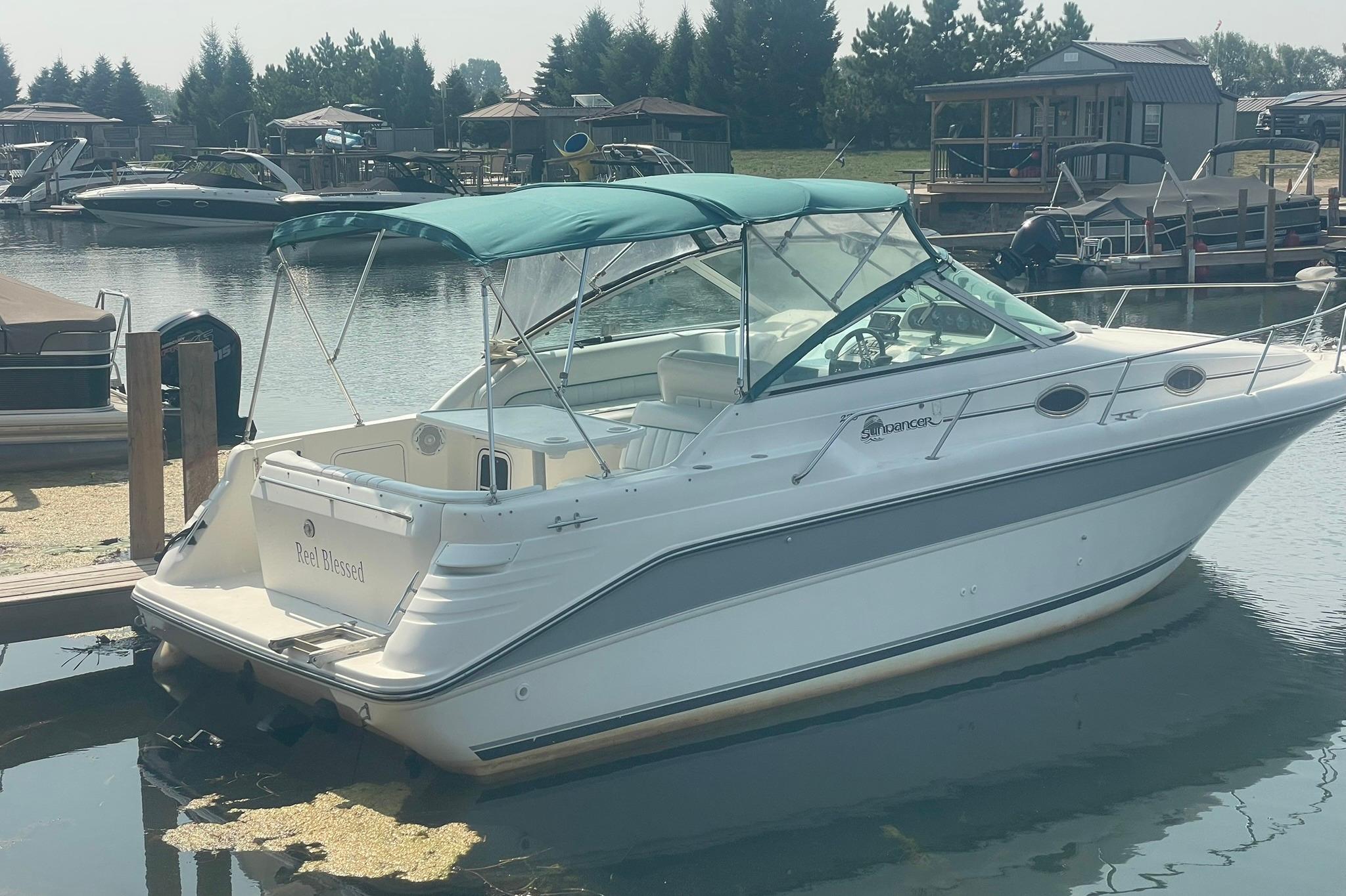 Sea Ray 270 Sundancer 1996 Sea Ray 270 Sundancer boat docked at a marina with green canopy.