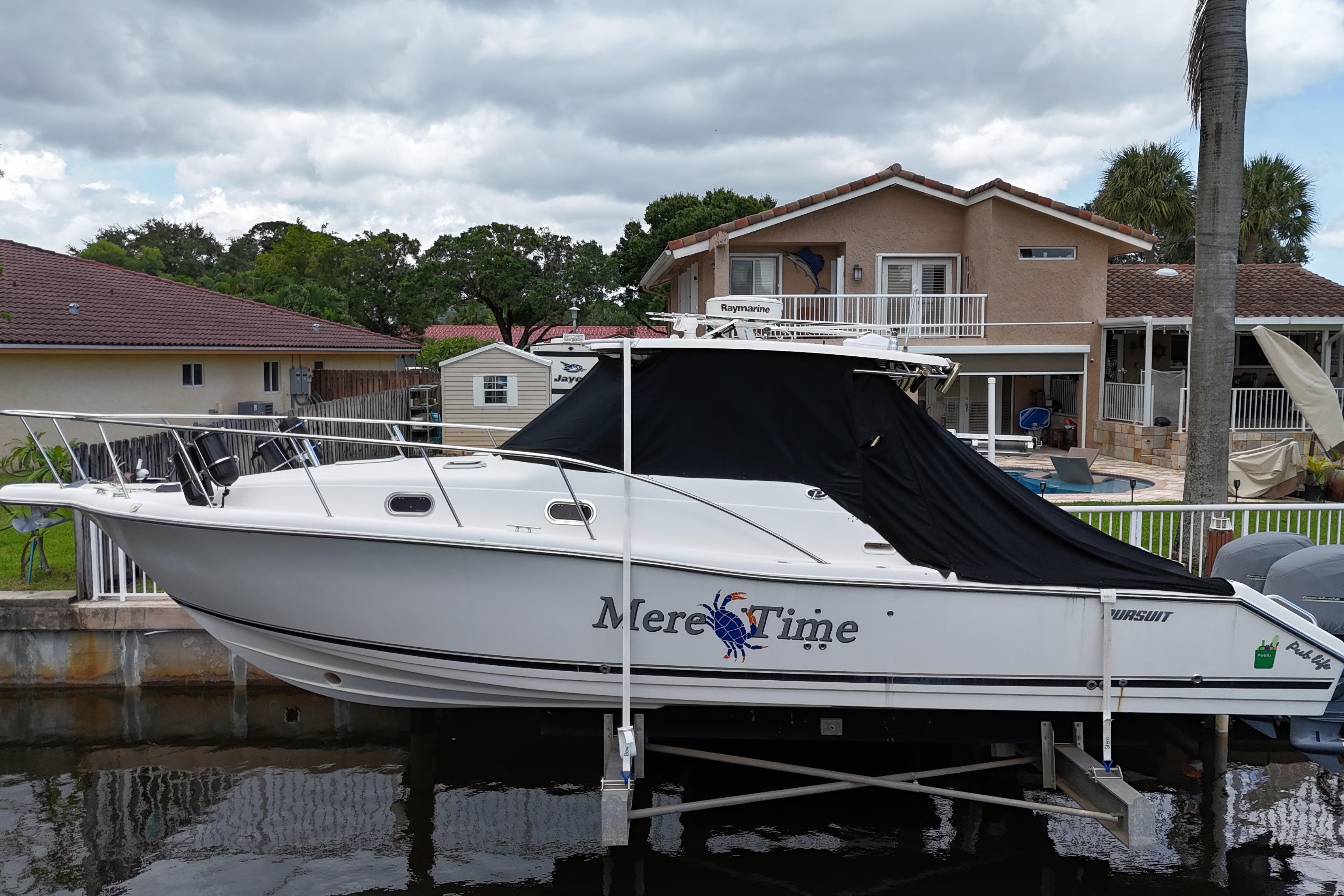 Pursuit OS 335 Offshore 2007 Pursuit OS 335 Offshore boat docked near a house, covered with a black tarp.
