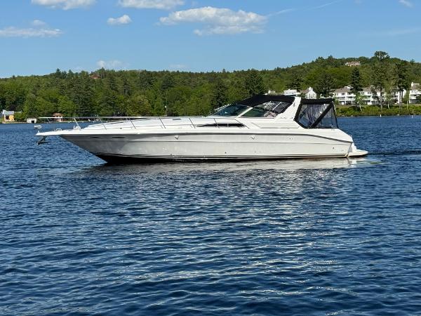 Sea Ray Express Cruiser 1992 Sea Ray Cruiser on a serene lake with lush green shoreline.