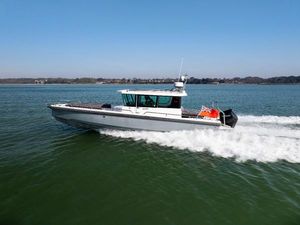 Axopar 28 CABIN 2020 Axopar 28 CABIN boat cruising on open water, side view.