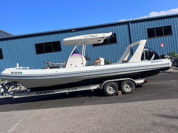 Brig EAGLE E780 2017 Brig EAGLE E780 boat on trailer, parked outside blue building.