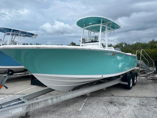 Sportsman Heritage 231 Center Console 2023 Sportsman Heritage 231 Center Console boat on trailer, turquoise hull, cloudy sky background.