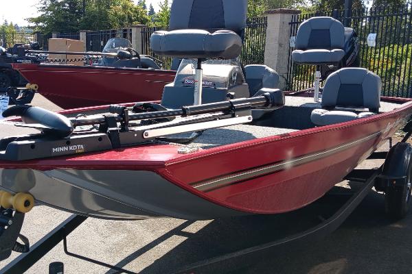 Tracker Bass Tracker Classic XL 2025 Tracker Bass Tracker Classic XL boat with red exterior and seating, parked outdoors.