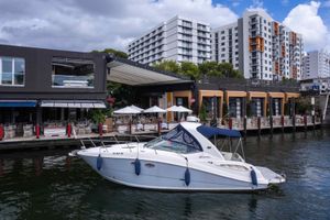 Sea Ray 290 Sundancer 2007 Sea Ray 290 Sundancer yacht docked near waterfront restaurant and modern buildings.