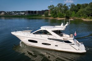 Regal 53 Sport Coupe 2015 Regal 53 Sport Coupe yacht cruising on a serene lake with lush greenery.