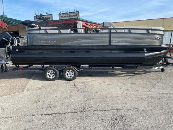 Regency 230 LE3 2023 Regency 230 LE3 pontoon boat on a trailer in a parking lot.