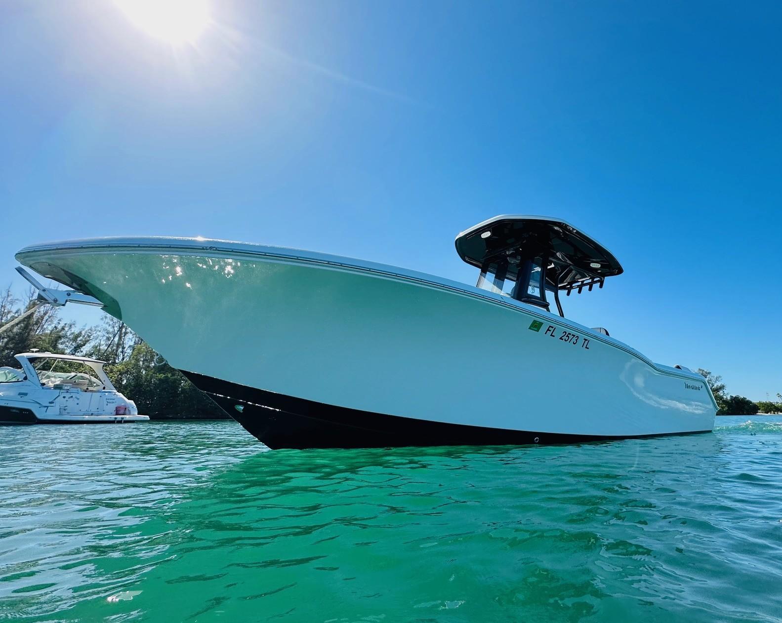 Tidewater 232 LXF 2023 Tidewater 232 LXF boat on clear turquoise water under bright blue sky.