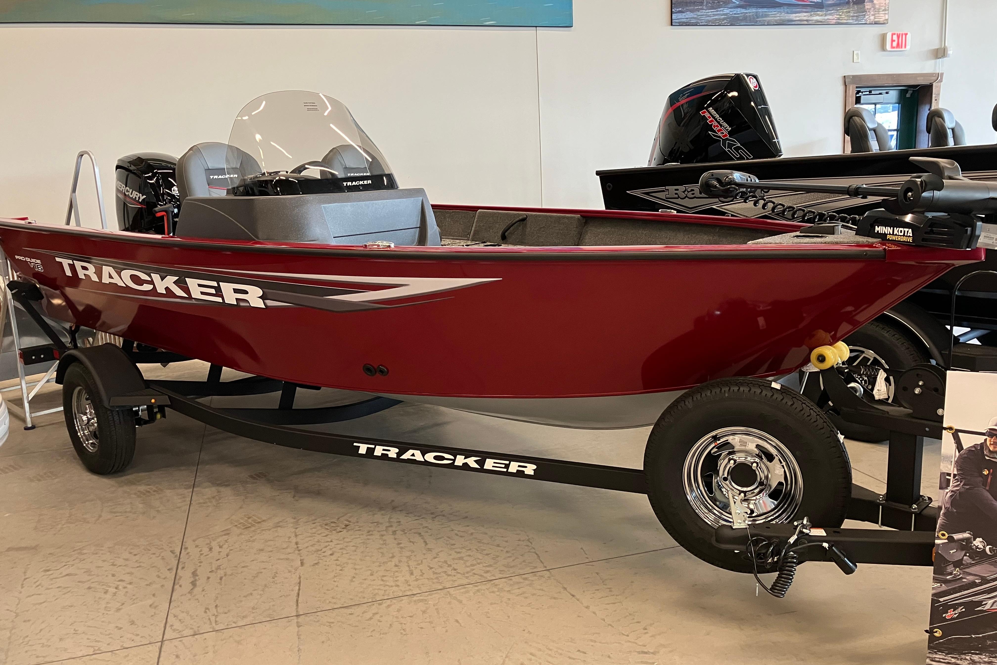 Tracker Pro Guide V-16 SC 2025 Tracker Pro Guide V-16 SC boat in showroom, red exterior, on trailer.