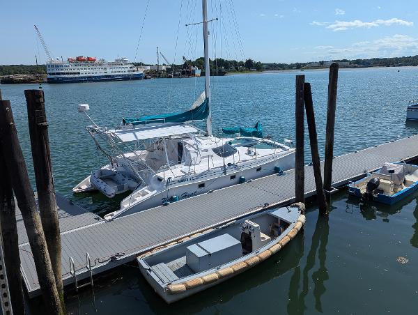 Manta 42 Manta 42 catamaran docked at marina, 2000 model, with scenic waterfront view.