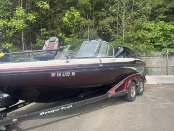 Ranger 1880MS 2023 Ranger 1880MS boat on trailer, parked outdoors with trees in the background.