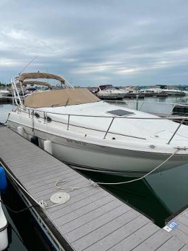 Sea Ray 270 Sundancer 2000 Sea Ray 270 Sundancer docked at marina under cloudy sky.