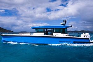 Axopar 37 Cross Cabin 2024 Axopar 37 Cross Cabin boat cruising on blue ocean waters under a cloudy sky.