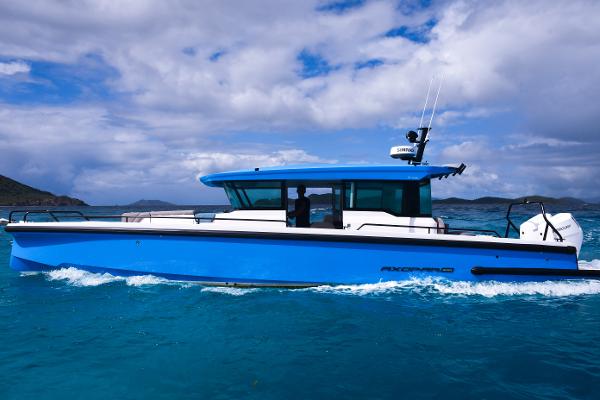 Axopar 37 Cross Cabin 2024 Axopar 37 Cross Cabin boat cruising on blue ocean waters under a cloudy sky.