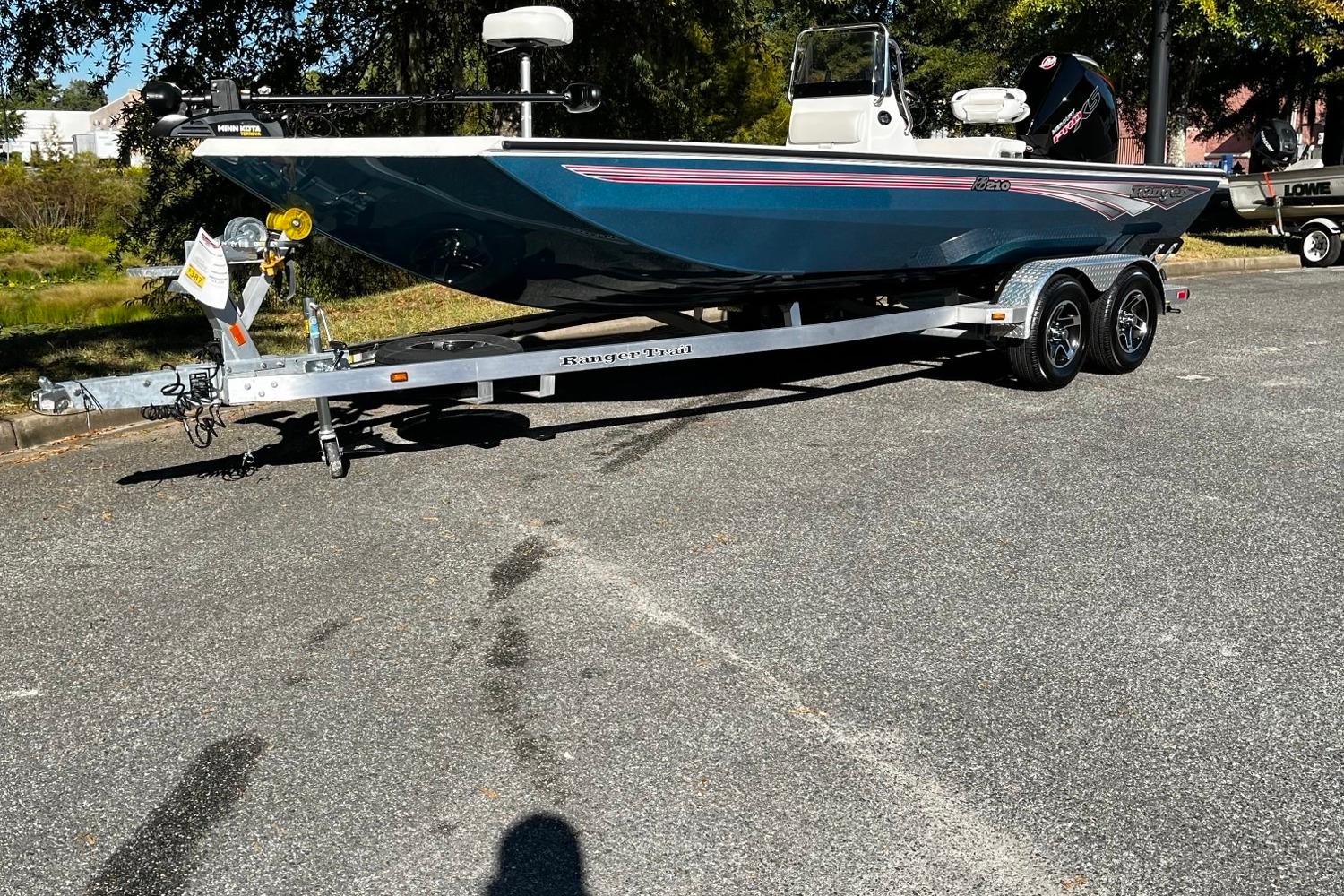 Ranger RB210 2025 Ranger RB210 boat on trailer, parked outdoors, showcasing sleek design and modern features.