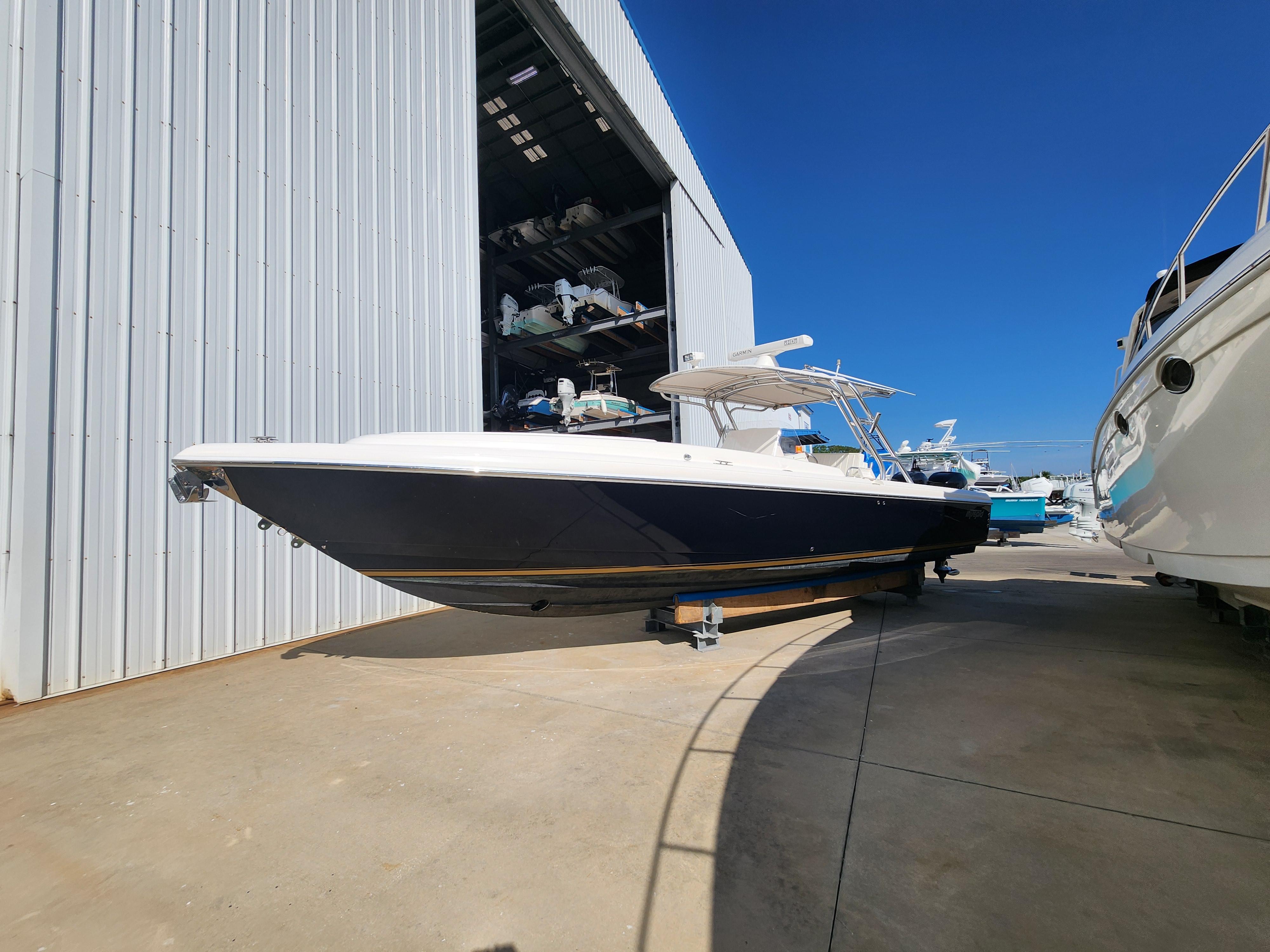 Intrepid 323 Cuddy 2008 Intrepid 323 Cuddy boat docked outside a large storage facility under clear blue skies.