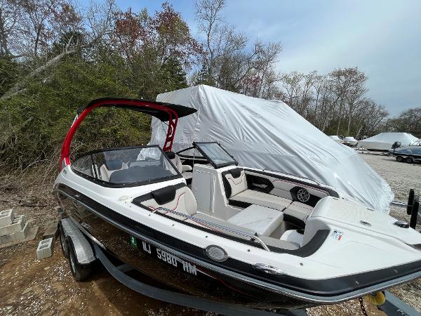Yamaha Boats 212X 2018 Yamaha Boats 212X on trailer, parked outdoors with cover in background.