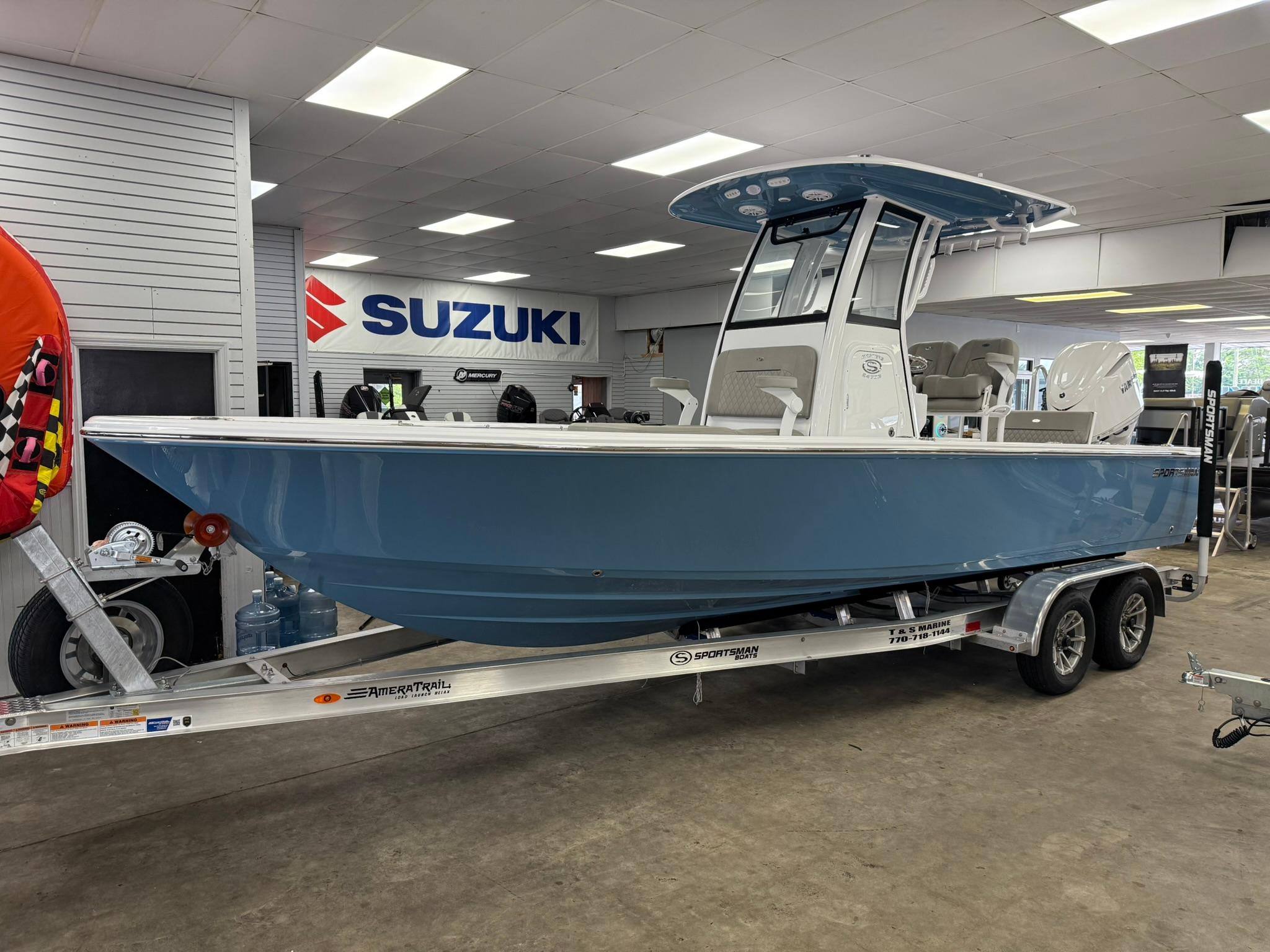 Sportsman Masters 247OE Bay Boat 2025 Sportsman Masters 247OE Bay Boat on trailer in showroom, Suzuki sign visible.