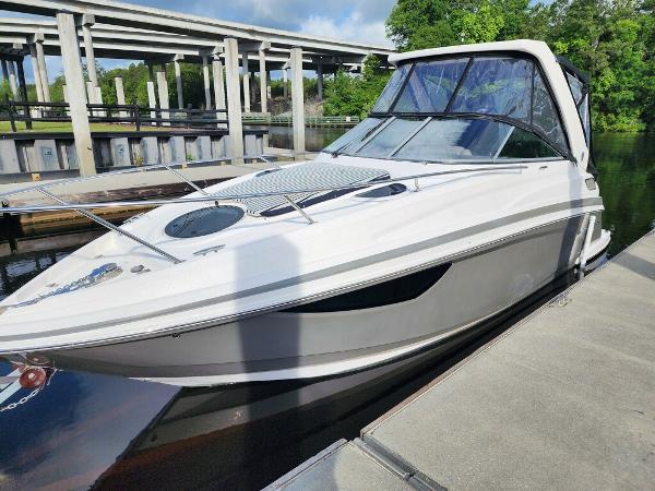 Regal 28 Express 2015 Regal 28 Express boat docked near a bridge on a sunny day.