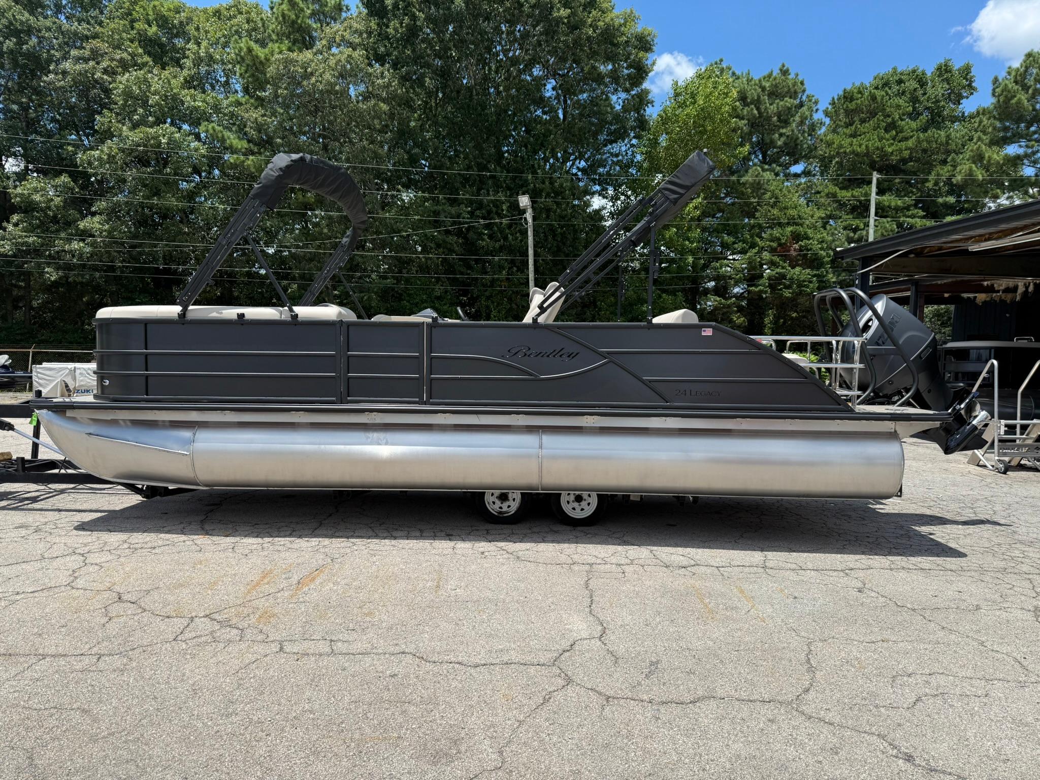 Bentley Pontoons Legacy 243 Swingback 2026 Bentley Pontoons Legacy 243 Swingback on trailer, parked outdoors, surrounded by trees.
