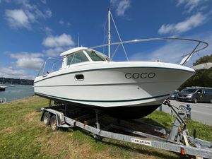 Jeanneau Merry Fisher 695 2004 Jeanneau Merry Fisher 695 boat on trailer, named "COCO," under a blue sky.