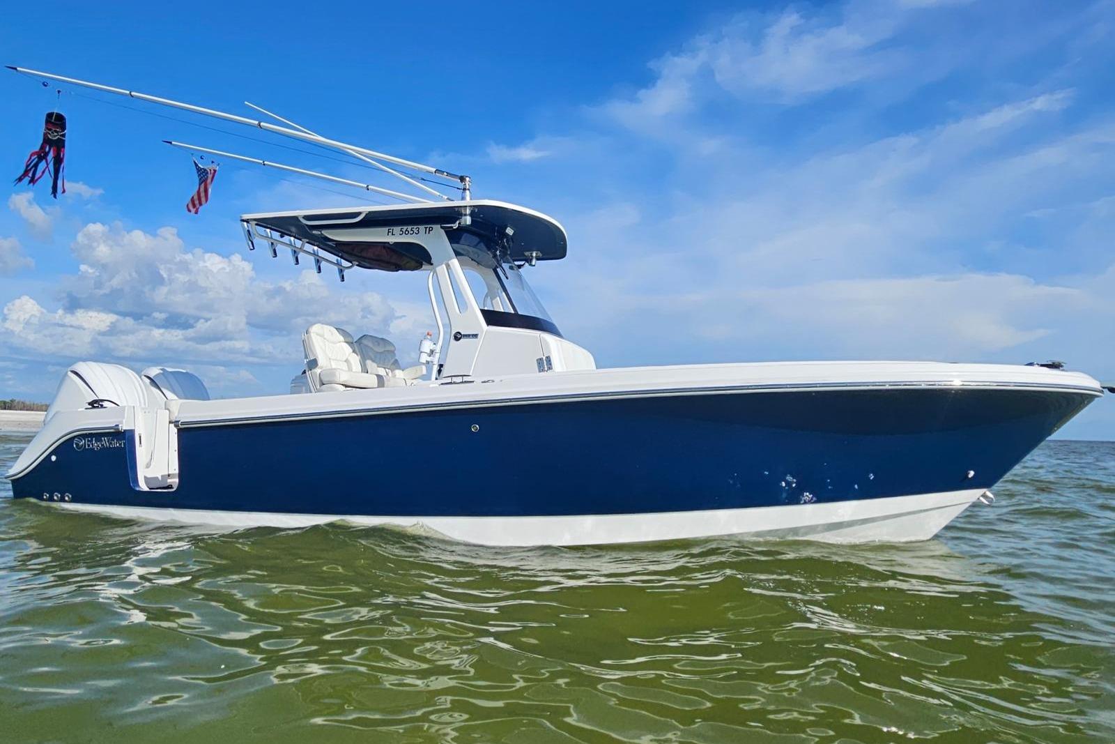 Edgewater 262CC 2023 Edgewater 262CC boat on water, blue hull, clear sky background.