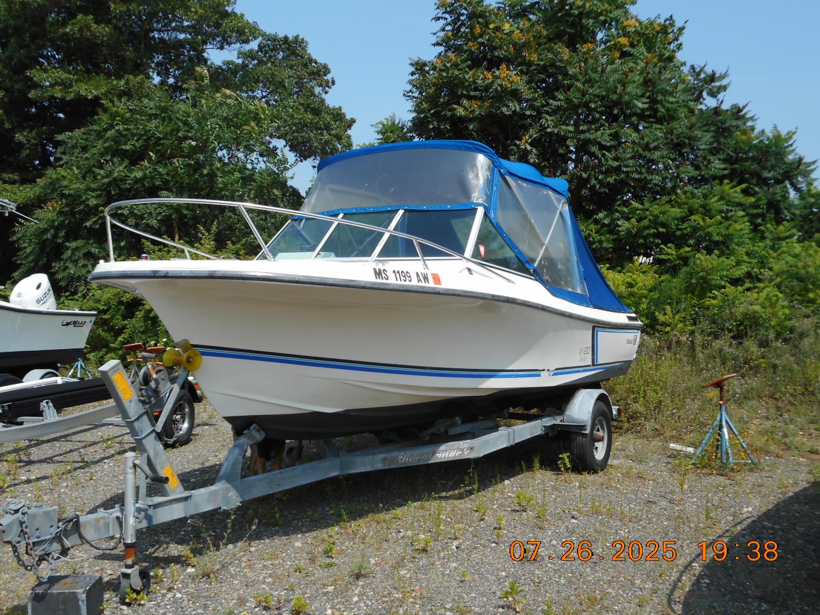 Wellcraft V20 Steplift 1988 Wellcraft V20 Steplift boat on trailer, parked outdoors with trees in background.