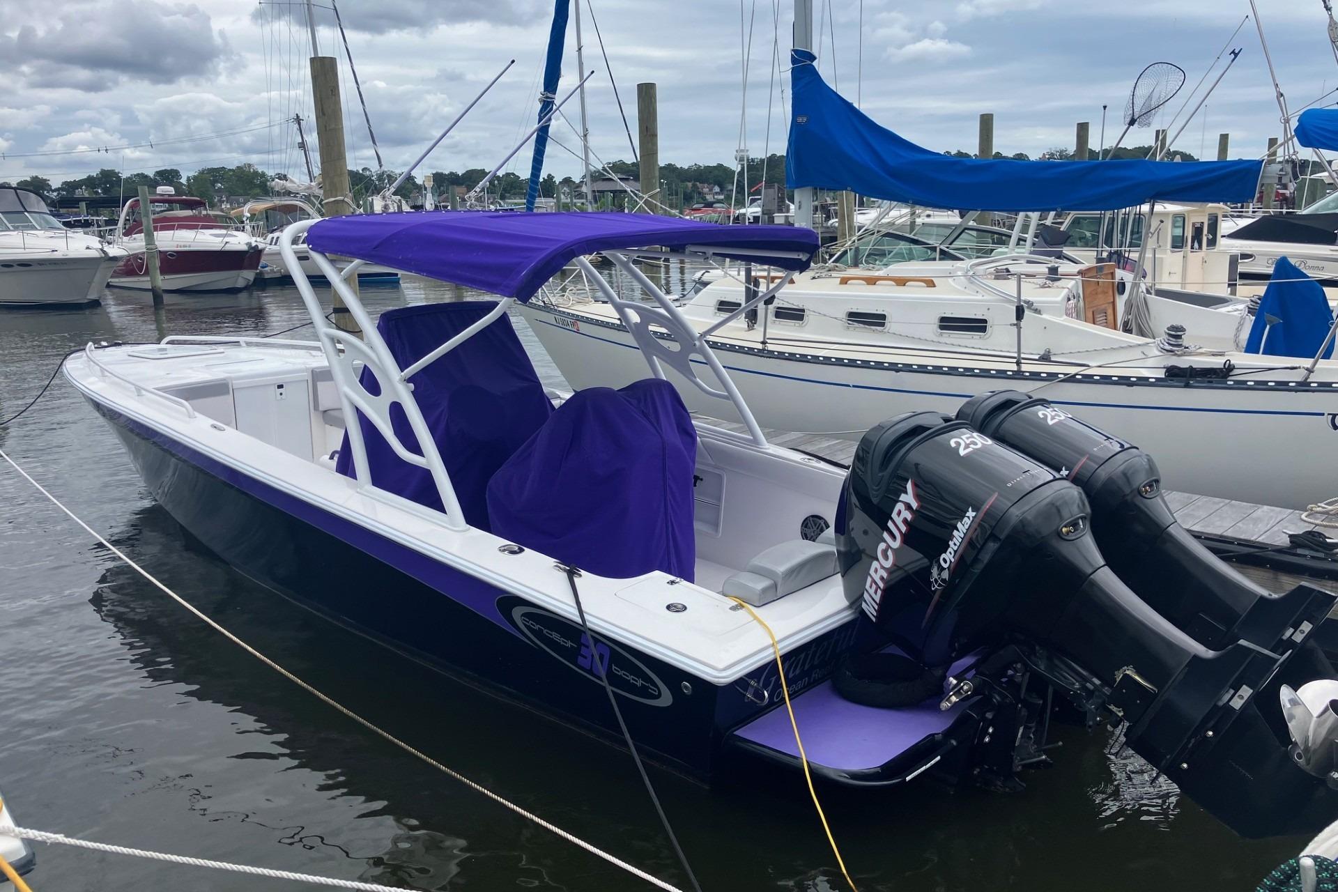 Concept 30 Cuddy 2014 Concept 30 Cuddy boat with purple canopy and twin Mercury engines docked at marina.