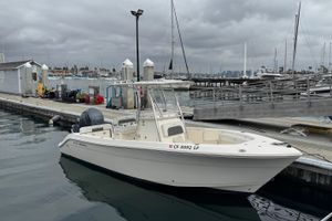 Cobia 237 Center Console 2022 Cobia 237 Center Console boat docked at marina under cloudy sky.