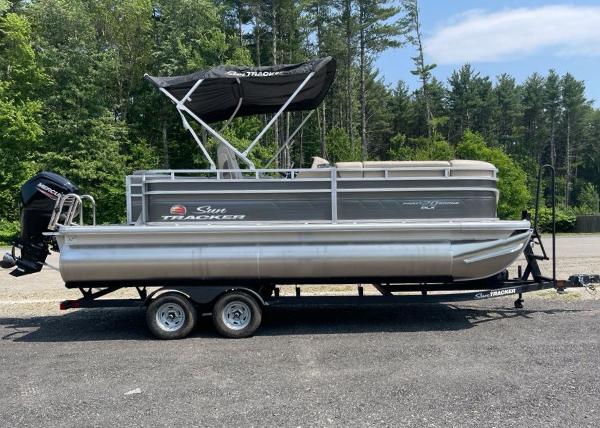 Sun Tracker Party Barge 20 DLX 2025 Sun Tracker Party Barge 20 DLX pontoon boat on trailer, parked outdoors.