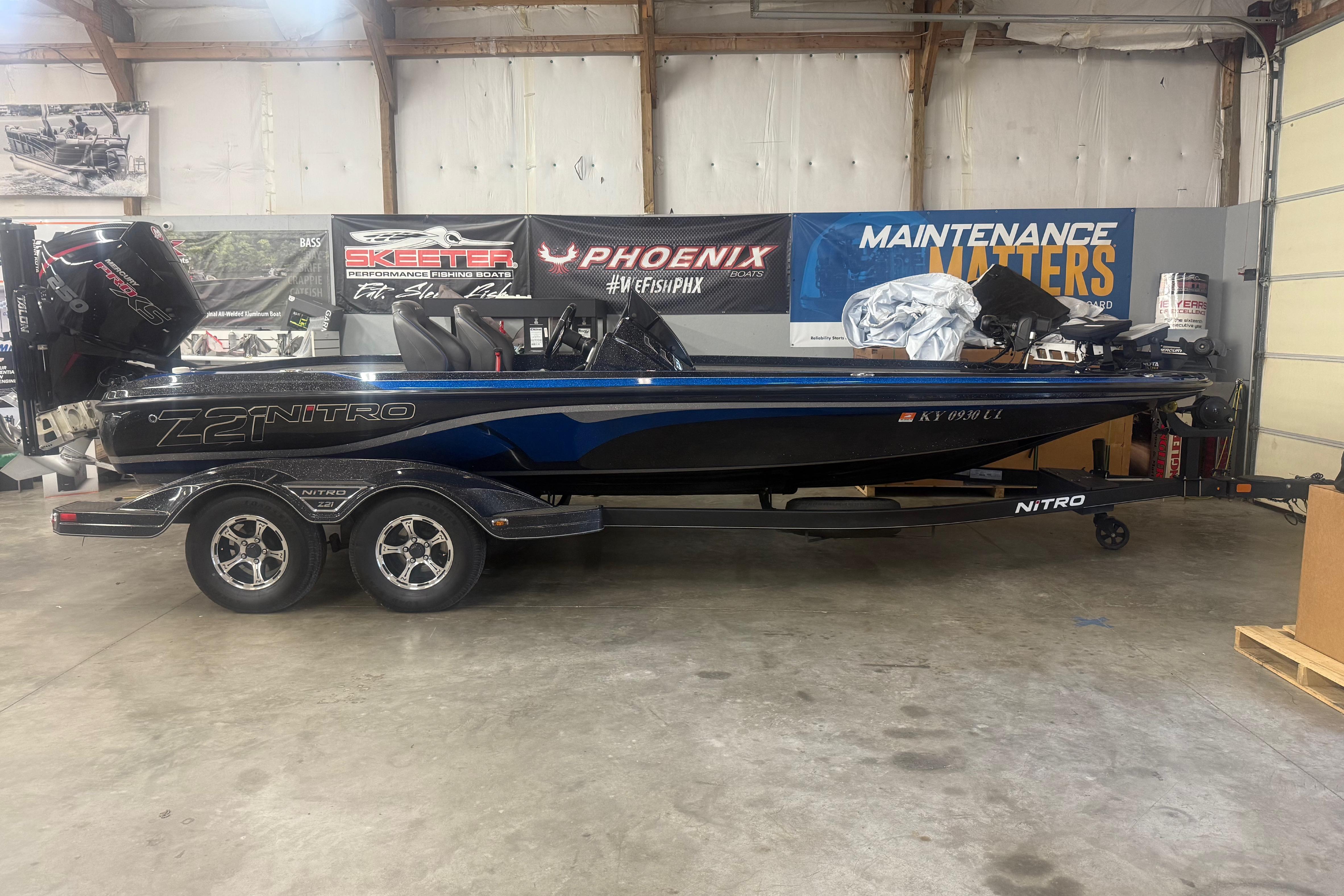 Nitro Z21 Pro 2021 Nitro Z21 Pro boat in a garage, featuring sleek design and dual-axle trailer.