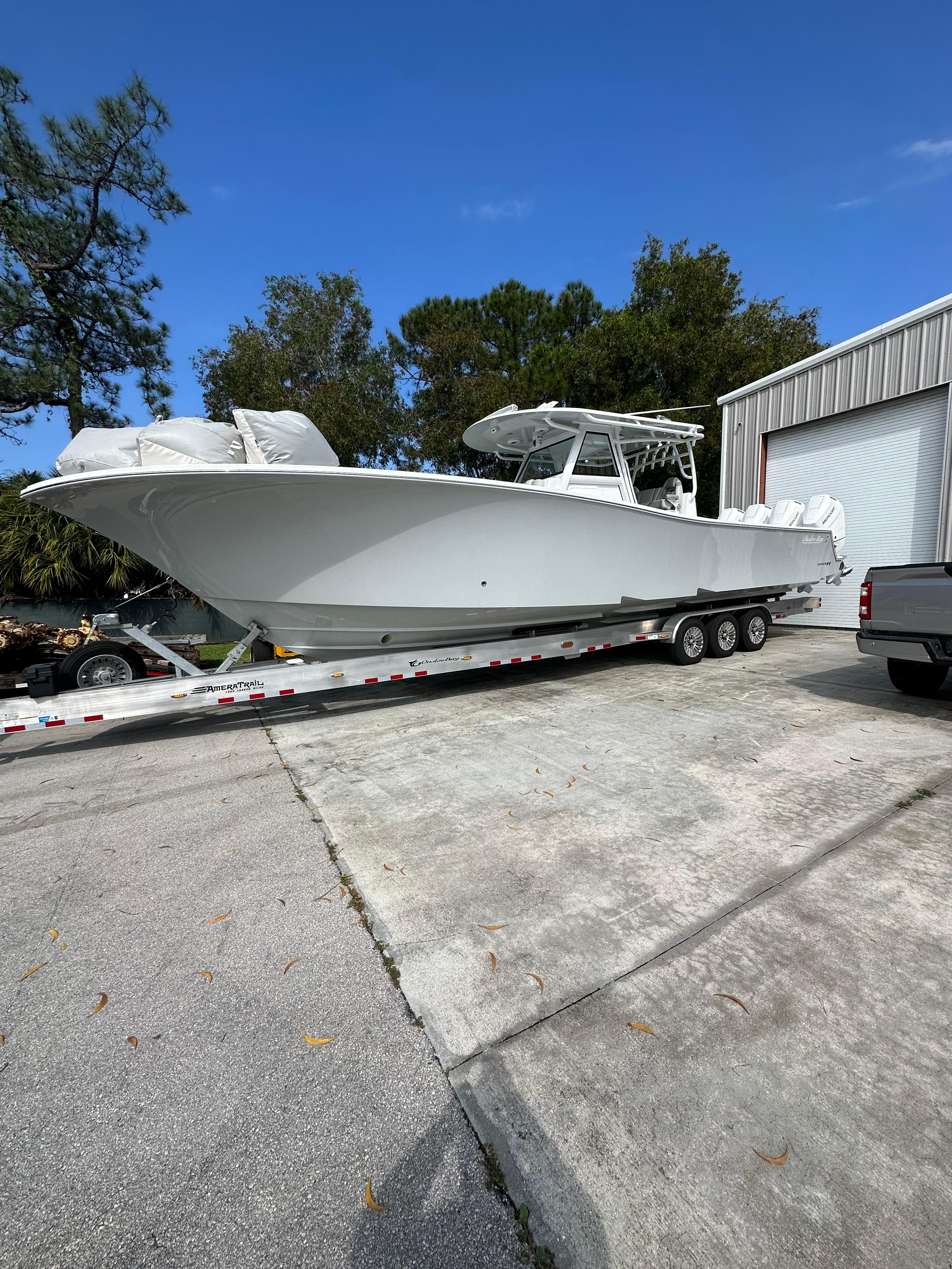 Onslow Bay 41 2024 Onslow Bay 41 boat on trailer, parked outdoors near a garage.