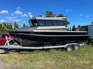 Custom Aluminum Fishing Custom 2022 aluminum fishing boat on trailer, parked outdoors under blue sky.