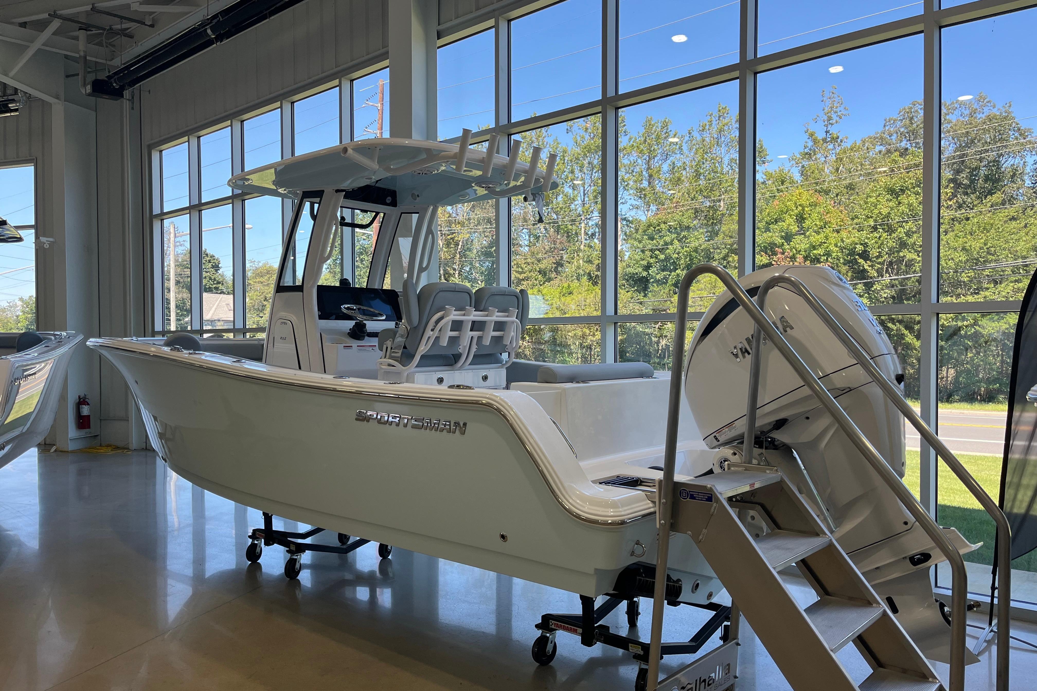 Sportsman Open 232 Center Console 2026 Sportsman Open 232 Center Console boat displayed indoors with large windows.