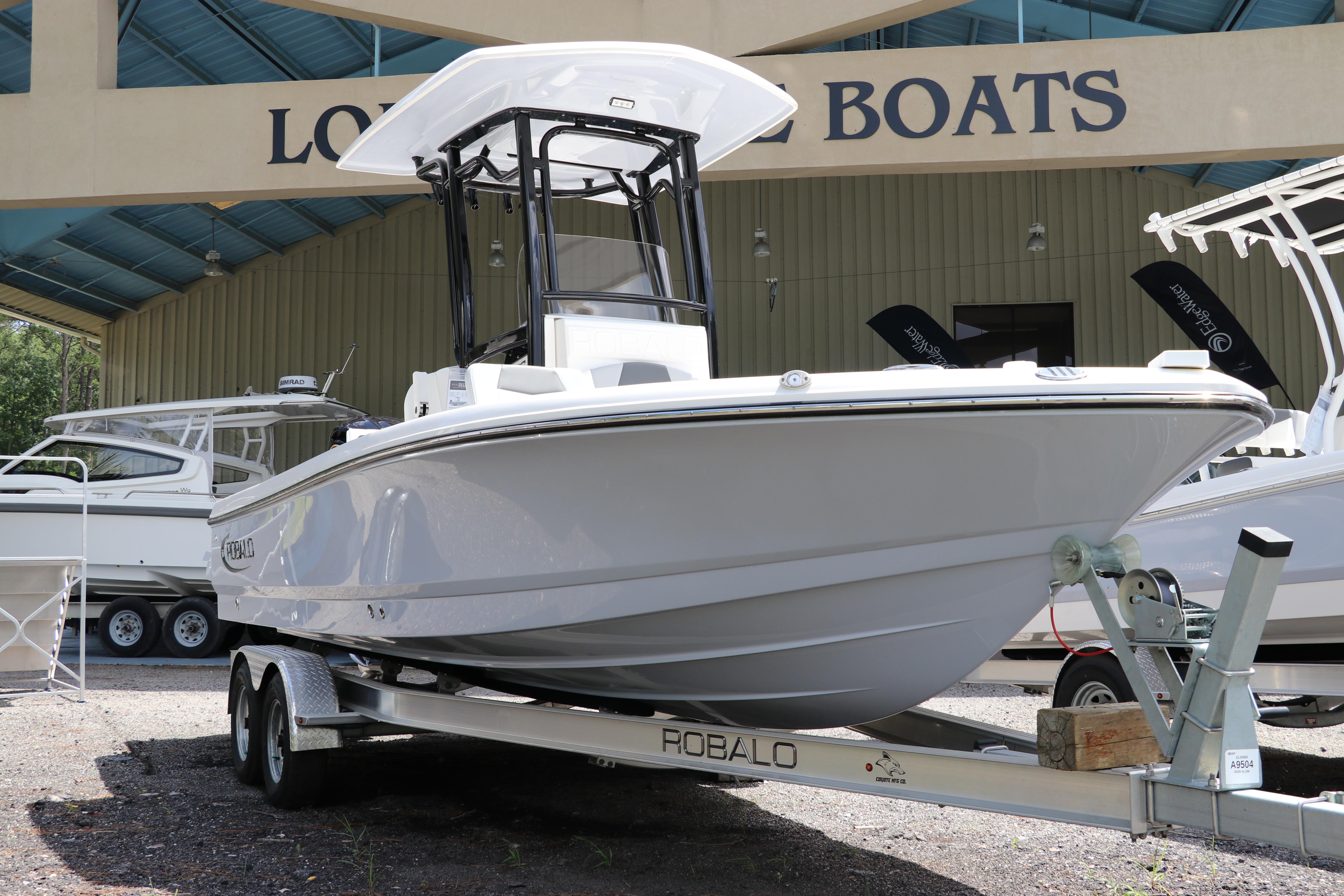 Robalo 226 Cayman 2025 Robalo 226 Cayman boat on trailer at dealership, showcasing sleek design.