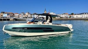 Invictus 320 GTS 2023 Invictus 320 GTS yacht cruising near coastal town under clear blue sky.