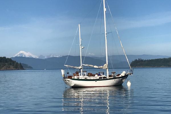 Hardin 45 1981 Hardin 45 sailboat anchored on calm water with scenic mountain backdrop.