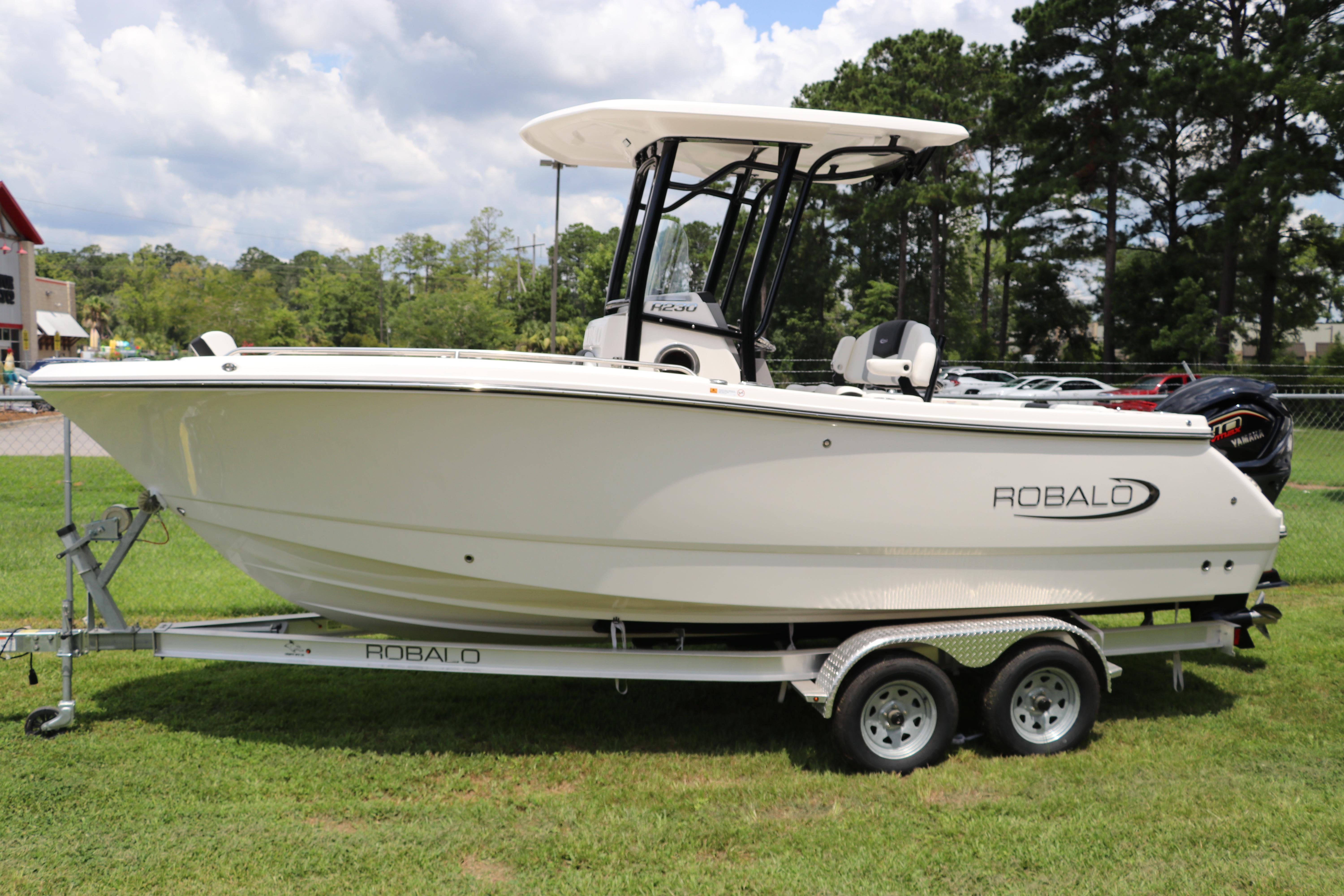 Robalo R230 Center Console 2024 Robalo R230 Center Console boat on trailer, parked on grass.