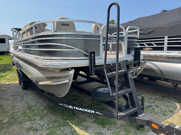 Sun Tracker Fishin' Barge 20 DLX 2023 Sun Tracker Fishin' Barge 20 DLX pontoon boat on trailer, parked outdoors.